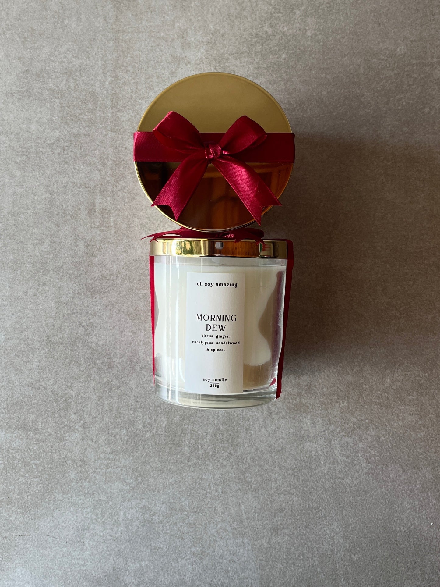 Candle with a red bow on a gray background